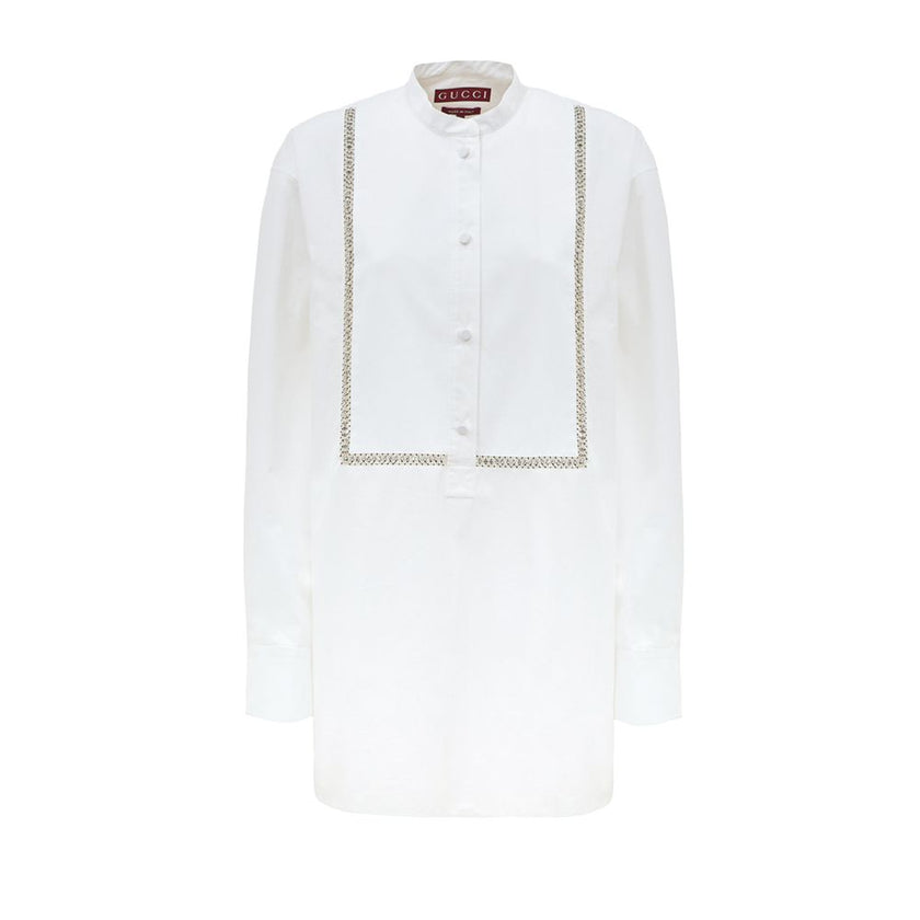 White Cotton BlouseWhite Cotton Poplin Blouse with Gucci Crystal Decorations. Front fastening with tone-on-tone fabric-covered buttons, round neckline, piqué panel, edge with crystal and bead details, rounded at the bottom Composition: 100% Cotton Interna