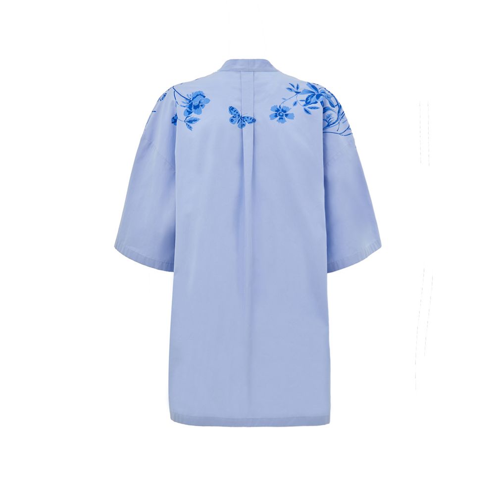 Blue Cotton Pattern ShirtLight Blue Cotton Poplin Kimono Shirt with Gucci Flower Print. Deep V-neckline with bow, iconic metal and leather horsebit applied on the front, two side welt pockets, rounded on the front and squared on the back. Contrasting flow
