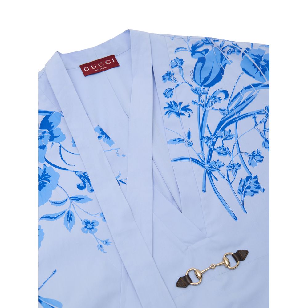 Blue Cotton Pattern ShirtLight Blue Cotton Poplin Kimono Shirt with Gucci Flower Print. Deep V-neckline with bow, iconic metal and leather horsebit applied on the front, two side welt pockets, rounded on the front and squared on the back. Contrasting flow