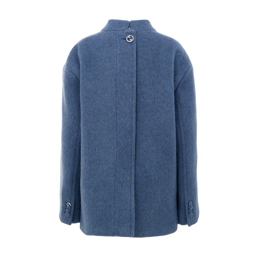Light Blue Wool CoatGucci Light Blue Wool Caban Jacket. Semi-Korean collar, front button fastening, two flap pockets on the sides and a breast pocket. On the back, covered button detail and Gucci logo metal button. Inner lining, regular fit. Composition: