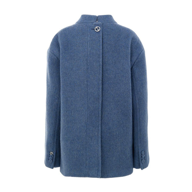 Light Blue Wool CoatGucci Light Blue Wool Caban Jacket. Semi-Korean collar, front button fastening, two flap pockets on the sides and a breast pocket. On the back, covered button detail and Gucci logo metal button. Inner lining, regular fit. Composition: