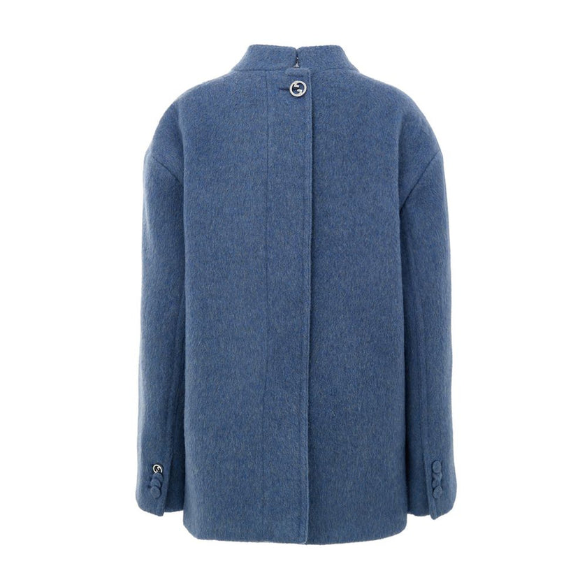 Light Blue Wool CoatGucci Light Blue Wool Caban Jacket. Semi-Korean collar, front button fastening, two flap pockets on the sides and a breast pocket. On the back, covered button detail and Gucci logo metal button. Inner lining, regular fit. Composition: