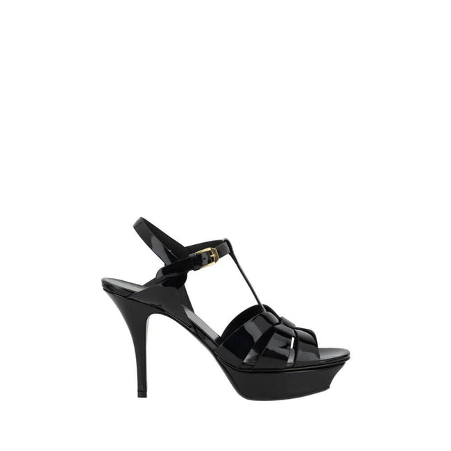 Tribute SandalsSaint Laurent’s Tribute Sandals are a timeless classic that combines elegance and boldness. Featuring a caged design on the upper, these sandals offer a sophisticated and sensual silhouette, enhanced by a patent leather finish that lends a