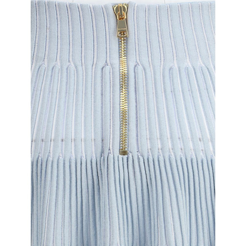 Light Blue Viscose Mini SkirtBalmain’s knit Miniskirt is distinguished by the embossed workmanship that gives structure and character to the garment. Equipped with a reinforced belt, it features a back closure with an exposed gold-metal zipper, embellishe