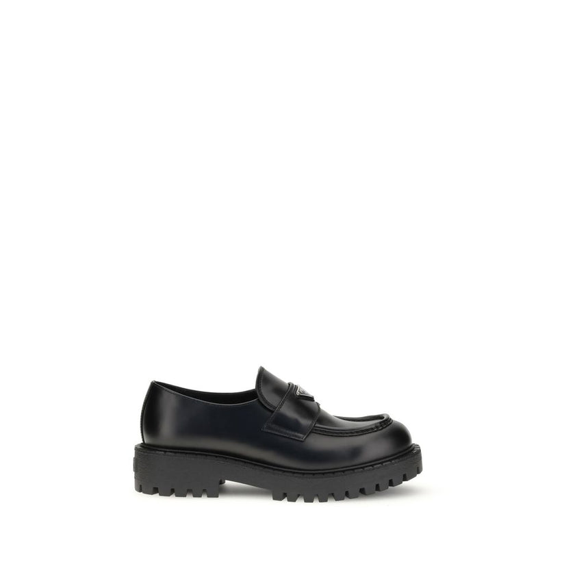 Black Calf Leather Bos Taurus Slip-On LoafersPrada’s leather Double Chocolate Loafers feature a band decorated with an enameled metal triangle, the brand’s distinctive symbol. They feature a stitched tray with burlotto and a volumetric rubber sole with do