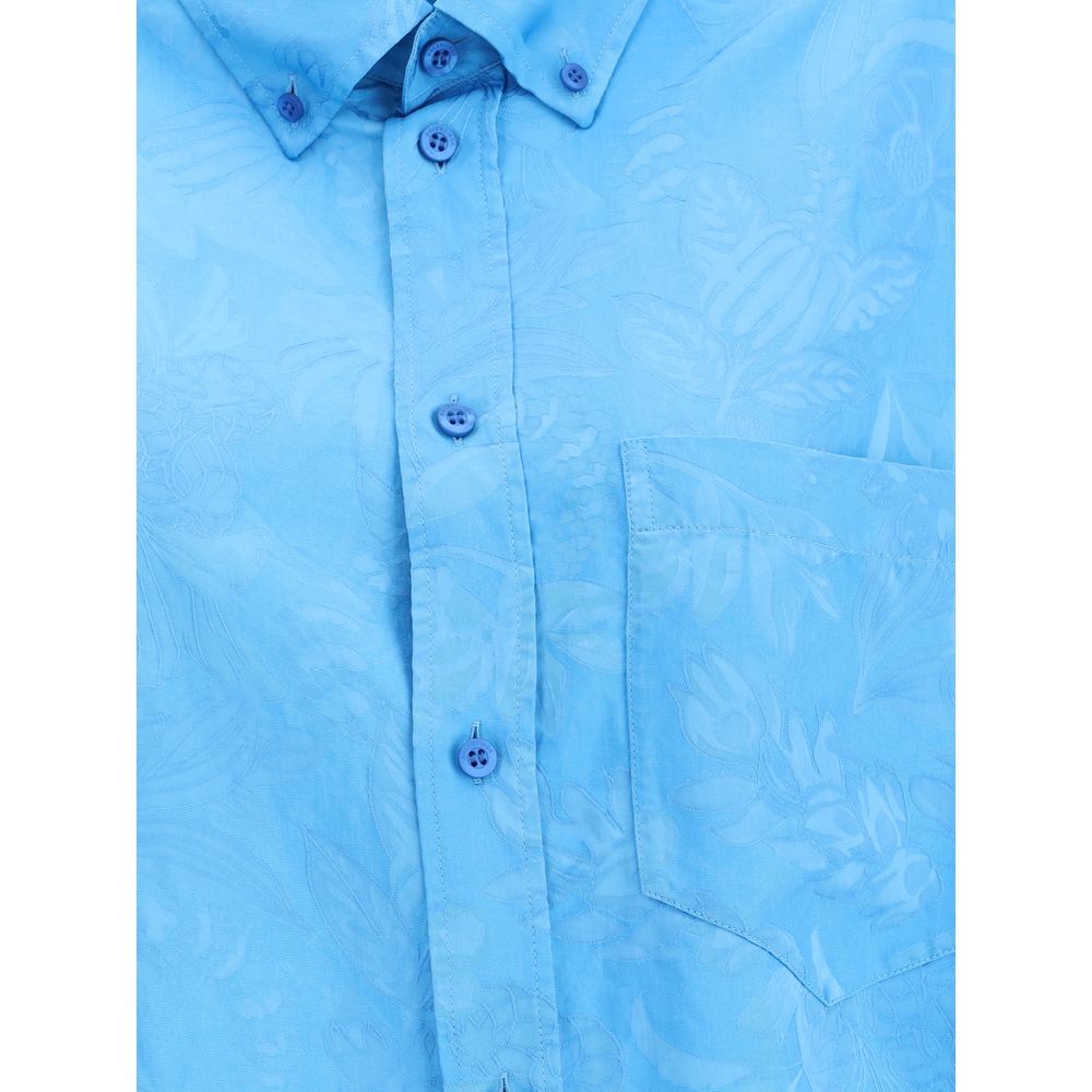 Blue Viscose Pattern ShirtBalenciaga’s Cocoon Shirt is made from a fine viscose-silk blend with a floral pattern, combining elegance and lightness. Featuring a cocoon silhouette with a rounded back, it has sloping shoulders, long sleeves and a hem that is