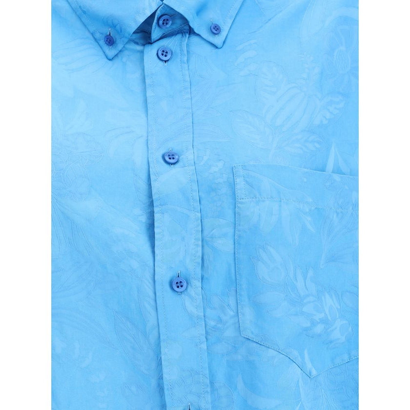 Blue Viscose Pattern ShirtBalenciaga’s Cocoon Shirt is made from a fine viscose-silk blend with a floral pattern, combining elegance and lightness. Featuring a cocoon silhouette with a rounded back, it has sloping shoulders, long sleeves and a hem that is