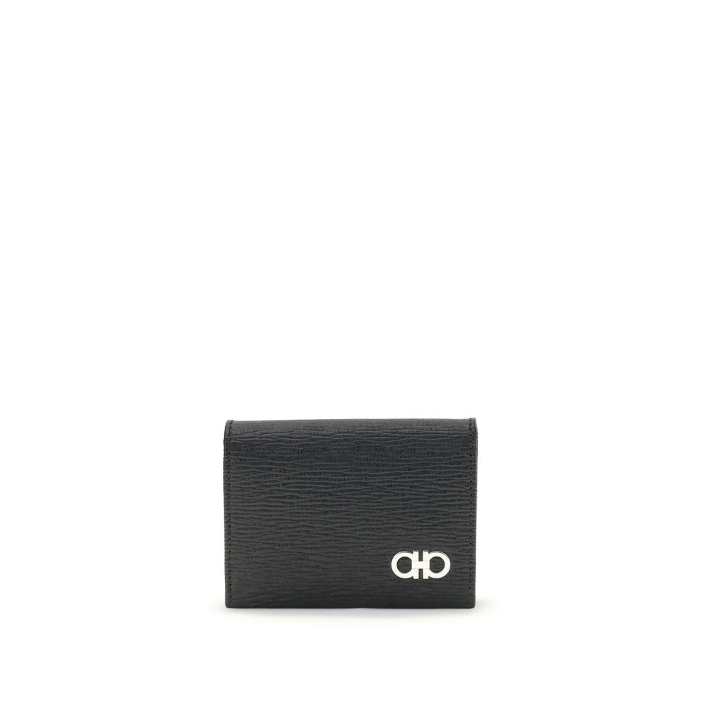 Black Leather WalletFerragamo’s Gancini Card Holder is a compact and elegant accessory with five internal compartments for cards and one dedicated to coins. The red interior gives a lively and refined touch, while the Gancini logo on the front signs the d