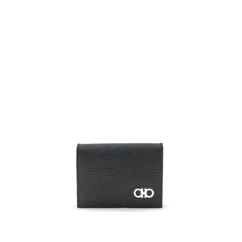 Black Leather WalletFerragamo’s Gancini Card Holder is a compact and elegant accessory with five internal compartments for cards and one dedicated to coins. The red interior gives a lively and refined touch, while the Gancini logo on the front signs the d