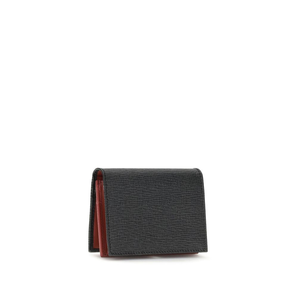 Black Leather WalletFerragamo’s Gancini Card Holder is a compact and elegant accessory with five internal compartments for cards and one dedicated to coins. The red interior gives a lively and refined touch, while the Gancini logo on the front signs the d