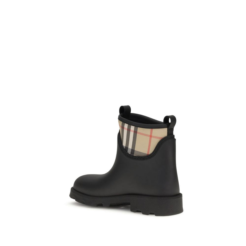 Black Rubber Ankle BootsBurberry’s Marsh Stamp Ankle Boots combine functionality with iconic style. Made of rubber, they are woven with the Burberry Check pattern in the classic sand color. The round toe and compact design make them ideal for rainy days,