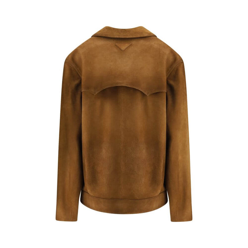 Brown Leather JacketPrada’s signature suede Jacket has an essential and refined design. Featuring a classic collar and a front button closure, it is completed by two welt pockets that enhance its clean lines. An iconic and versatile garment, perfect for a