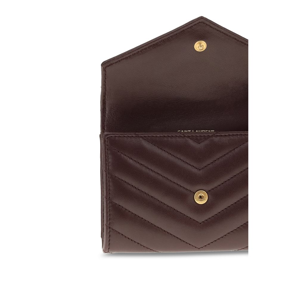 WalletThe Saint Laurent Cassandre leather Wallet combines elegance and functionality with a quilted matelassé design and front flap with magnetic closure. Embellished with the iconic three-dimensional metal YSL logo, it features a coin compartment, card s