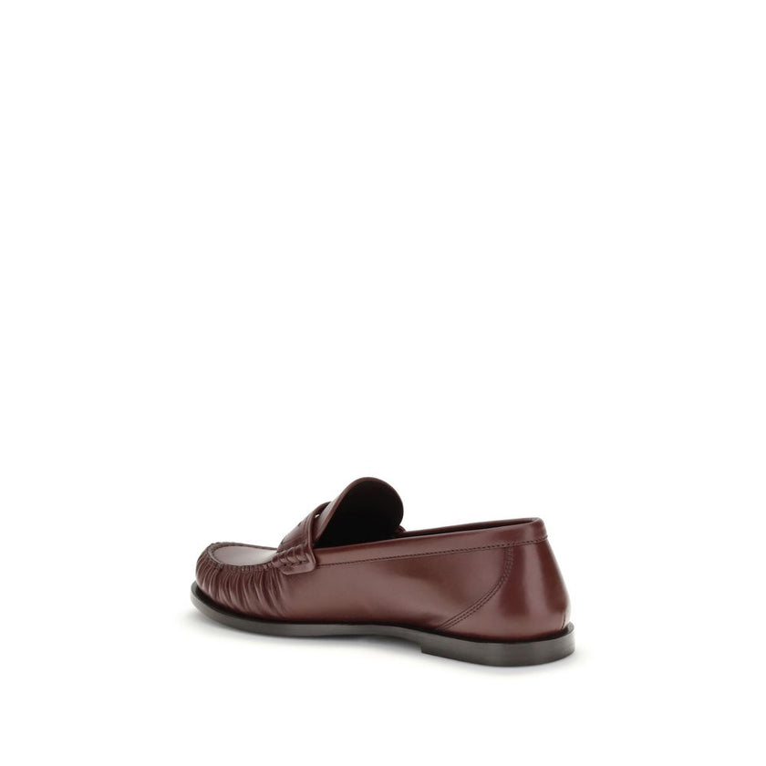 Brown Calf Leather Bos Taurus Slip-On LoafersSaint Laurent’s Laurent Loafers are a sleek, modern interpretation of the classic loafer. Featuring a hand-sewn square moc toe, they combine craftsmanship and contemporary design. The gold metal Cassandre decor