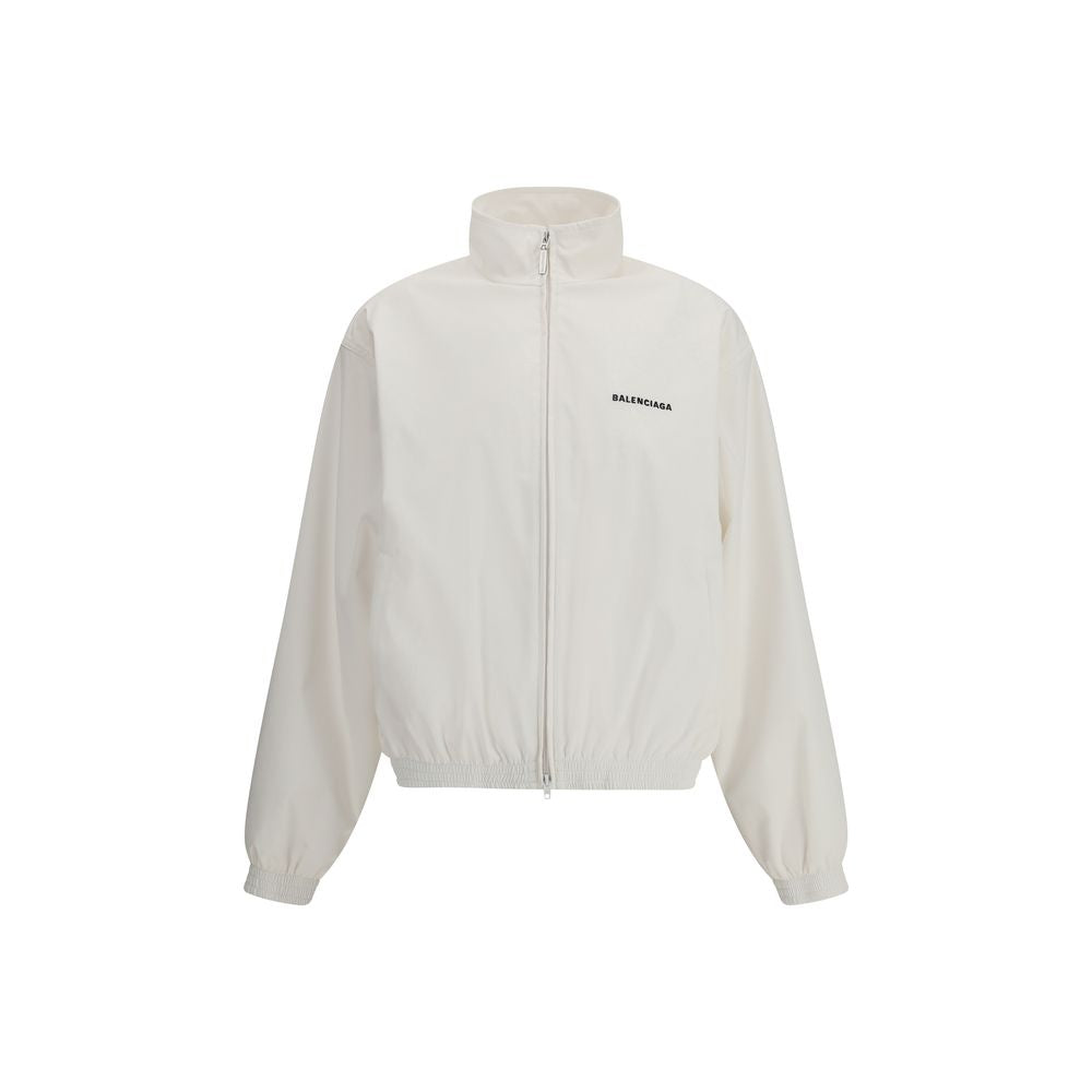 White Polyester Shell JacketBalenciaga’s Windbreaker Jacket is made of technical fabric and features contrasting logo embroidery on the chest and back. Featuring a high collar and concealed zipper closure, it offers two front zipper pockets. Gathered elas