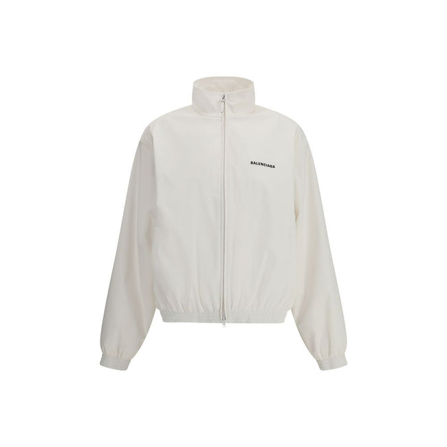 White Polyester Shell JacketBalenciaga’s Windbreaker Jacket is made of technical fabric and features contrasting logo embroidery on the chest and back. Featuring a high collar and concealed zipper closure, it offers two front zipper pockets. Gathered elas