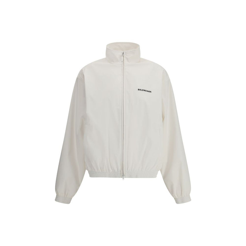 White Polyester Shell JacketBalenciaga’s Windbreaker Jacket is made of technical fabric and features contrasting logo embroidery on the chest and back. Featuring a high collar and concealed zipper closure, it offers two front zipper pockets. Gathered elas