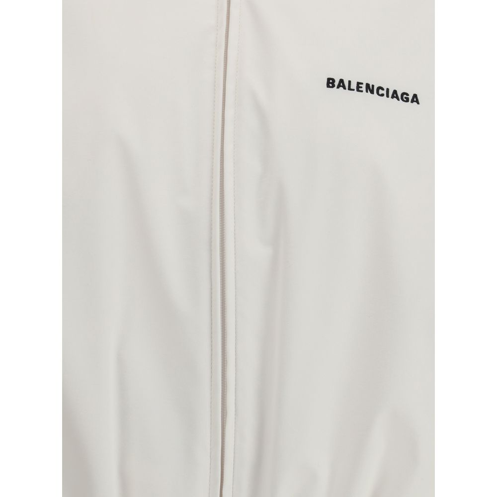 White Polyester Shell JacketBalenciaga’s Windbreaker Jacket is made of technical fabric and features contrasting logo embroidery on the chest and back. Featuring a high collar and concealed zipper closure, it offers two front zipper pockets. Gathered elas