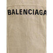 Beige Cotton Denim JacketThe oversized Denim Jacket by Balenciaga features a 7-button closure, front flap pockets and side slit pockets. Adjustable cuffs and waist with Balenciaga engraved metal buttons. The embroidered logo on the back elegantly signs th