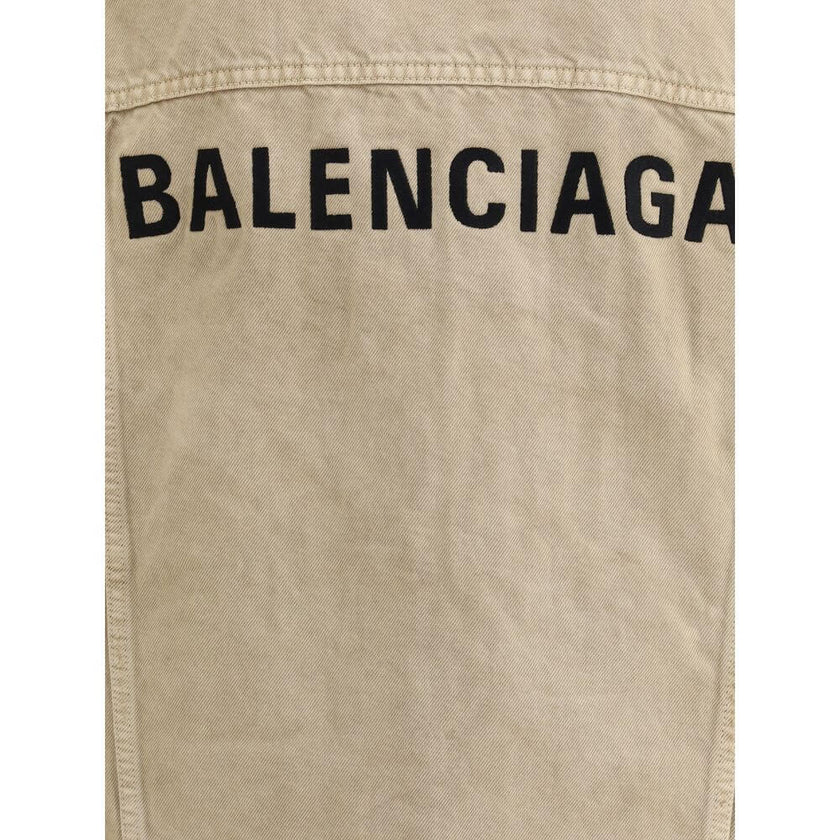 Beige Cotton Denim JacketThe oversized Denim Jacket by Balenciaga features a 7-button closure, front flap pockets and side slit pockets. Adjustable cuffs and waist with Balenciaga engraved metal buttons. The embroidered logo on the back elegantly signs th