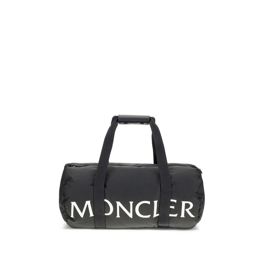 Black Nylon Luggage And TravelThe Moncler duffle Travel Bag combines functionality and style in a sporty, elegant design. Crafted from nylon with DIST-certified down padding, it features leather-tab handles with snap buttons, as well as an adjustable and