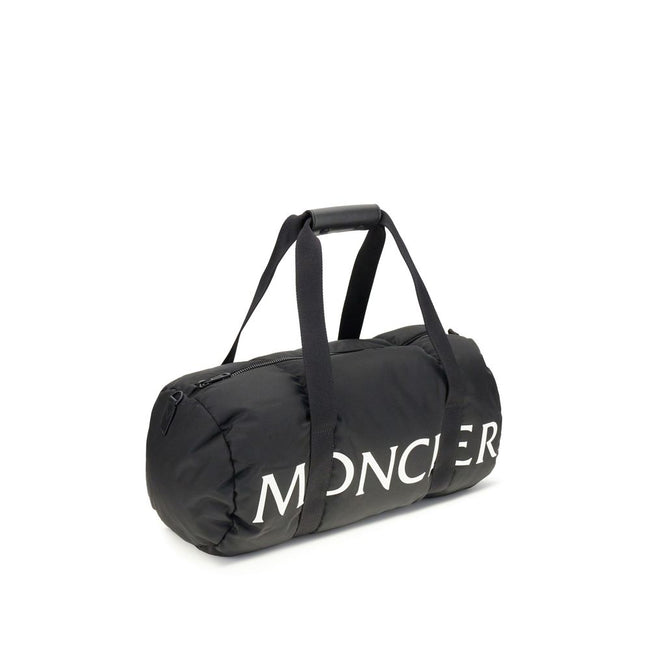 Black Nylon Luggage And TravelThe Moncler duffle Travel Bag combines functionality and style in a sporty, elegant design. Crafted from nylon with DIST-certified down padding, it features leather-tab handles with snap buttons, as well as an adjustable and