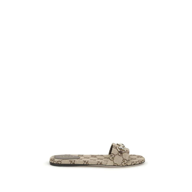 GG canvas SlippersThese Gucci GG canvas Slippers combine elegance and recognizability thanks to the brand’s iconic motif. Embellished with a refined metal horsebit detail on the instep, they feature a round toe for a classic touch. The logo label on the i