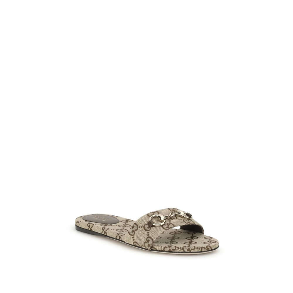 GG canvas SlippersThese Gucci GG canvas Slippers combine elegance and recognizability thanks to the brand’s iconic motif. Embellished with a refined metal horsebit detail on the instep, they feature a round toe for a classic touch. The logo label on the i
