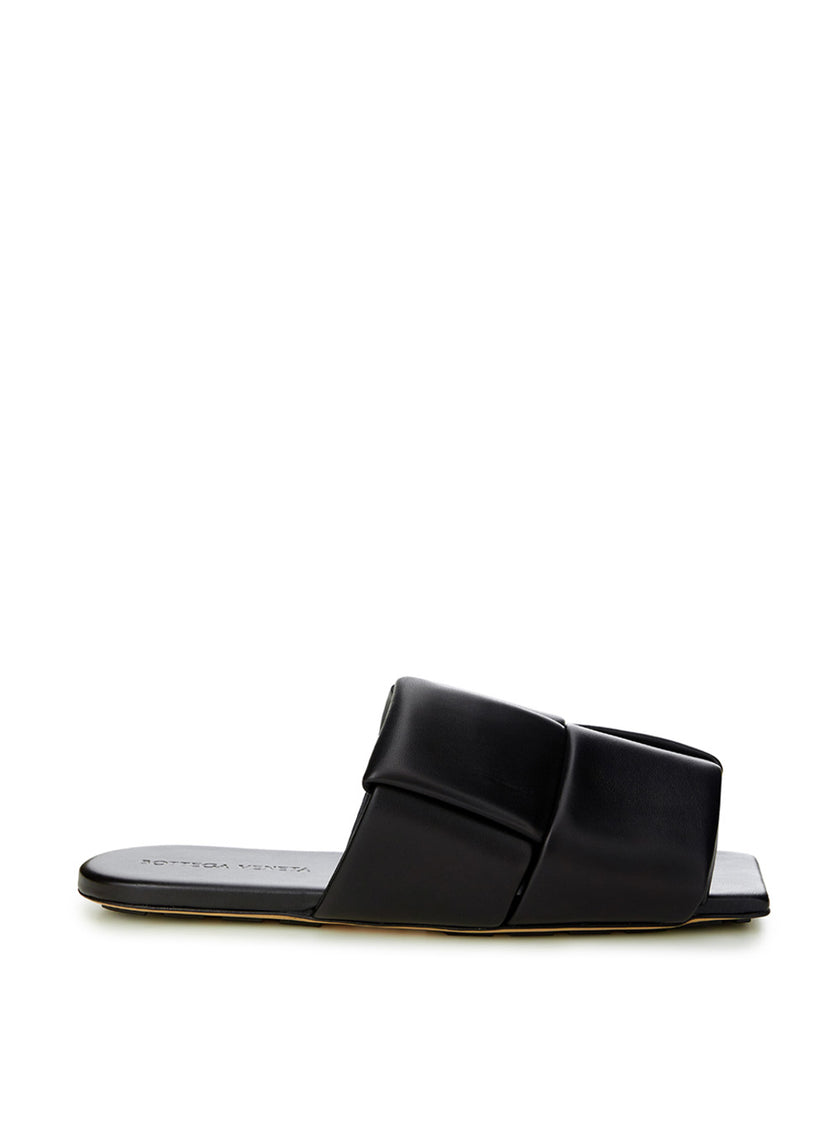 Elegant Black Leather SandalsStep into luxurious simplicity with these elegantly crafted black leather sandals by Bottega Veneta. Perfect for any occasion, they seamlessly blend high-end craftsmanship with sleek design, embodying Italian sophistication. I