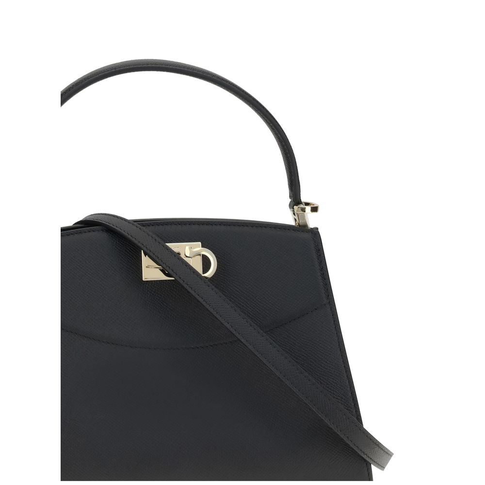 Black Calf Leather Bos Taurus HandbagFerragamo’s Studio Box Bag combines structured elegance and iconic details of the Maison. With trapezoid lines and a ladylike allure, it is embellished with rounded stitching on the front and the Gancini slider closure