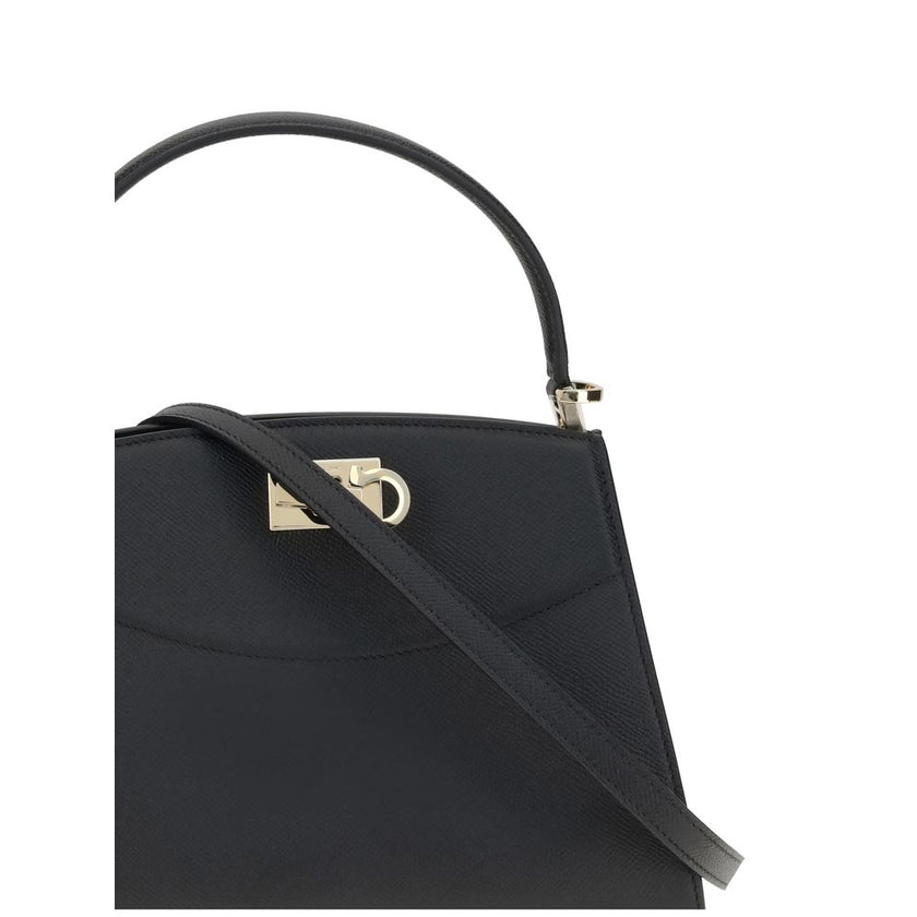 Black Calf Leather Bos Taurus HandbagFerragamo’s Studio Box Bag combines structured elegance and iconic details of the Maison. With trapezoid lines and a ladylike allure, it is embellished with rounded stitching on the front and the Gancini slider closure