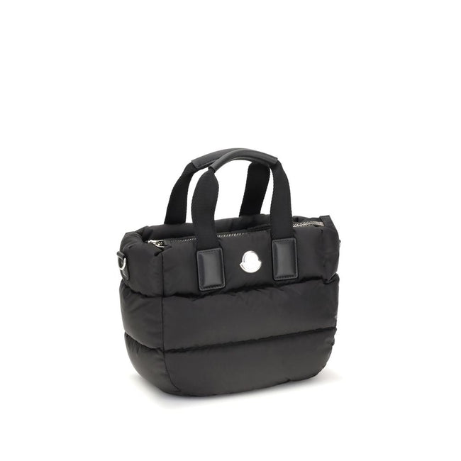 Black Polyamide HandbagThe Moncler Caradoc mini Tote Bag combines functionality and contemporary style. Crafted from water-repellent nylon, it features a perforated nylon lining and down padding for lightweight protection. Ribbon handles with leather grip