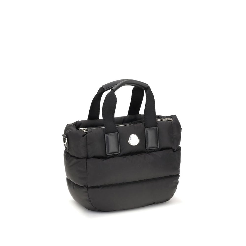 Black Polyamide HandbagThe Moncler Caradoc mini Tote Bag combines functionality and contemporary style. Crafted from water-repellent nylon, it features a perforated nylon lining and down padding for lightweight protection. Ribbon handles with leather grip