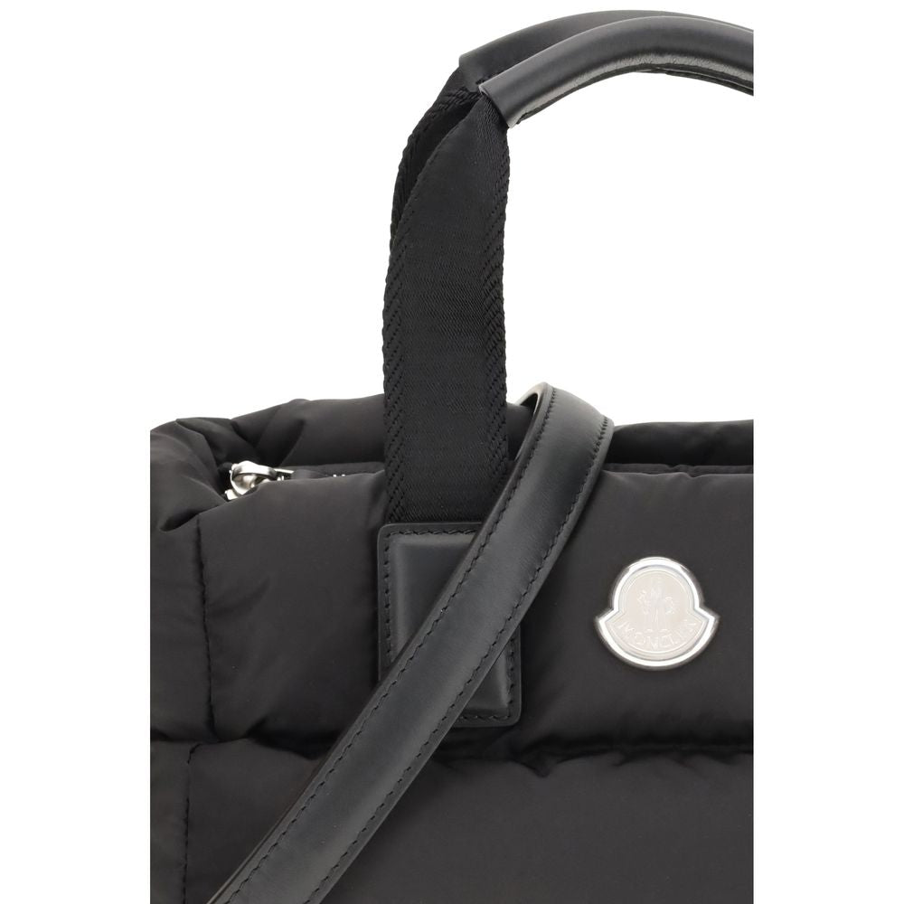 Black Polyamide HandbagThe Moncler Caradoc mini Tote Bag combines functionality and contemporary style. Crafted from water-repellent nylon, it features a perforated nylon lining and down padding for lightweight protection. Ribbon handles with leather grip