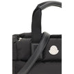 Black Polyamide HandbagThe Moncler Caradoc mini Tote Bag combines functionality and contemporary style. Crafted from water-repellent nylon, it features a perforated nylon lining and down padding for lightweight protection. Ribbon handles with leather grip