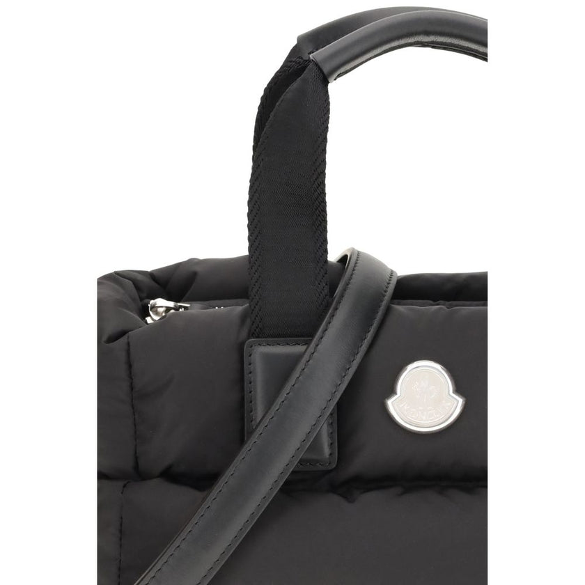 Black Polyamide HandbagThe Moncler Caradoc mini Tote Bag combines functionality and contemporary style. Crafted from water-repellent nylon, it features a perforated nylon lining and down padding for lightweight protection. Ribbon handles with leather grip