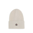 Wool beanie HatMoncler’s wool beanie Hat combines functionality and style in a ribbed design with a modern character. Soft and warm, it is ideal for facing cold days with comfort and personality. A stitched ion logo patch stands out on the front, giving i