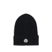 Wool beanie HatMoncler’s wool beanie Hat combines functionality and style in a ribbed design with a modern character. Soft and warm, it is ideal for facing cold days with comfort and personality. A stitched ion logo patch stands out on the front, giving i