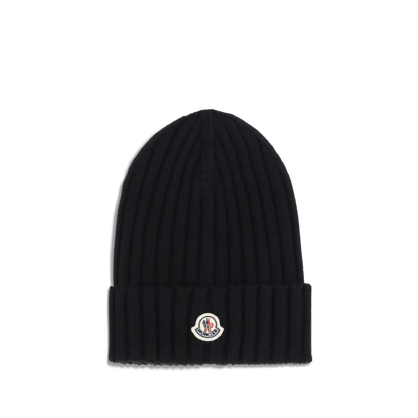 Wool beanie HatMoncler’s wool beanie Hat combines functionality and style in a ribbed design with a modern character. Soft and warm, it is ideal for facing cold days with comfort and personality. A stitched ion logo patch stands out on the front, giving i