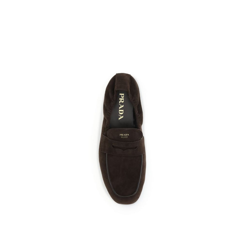 Brown Lamb Ovis Aries Aries Slip-On LoafersPrada’s Shuffle Loafers are made of suede and feature a sleek and contemporary leather horsebit upper. The screen-printed logo adds a refined touch, while the rubber sole with branded logo combines style and func