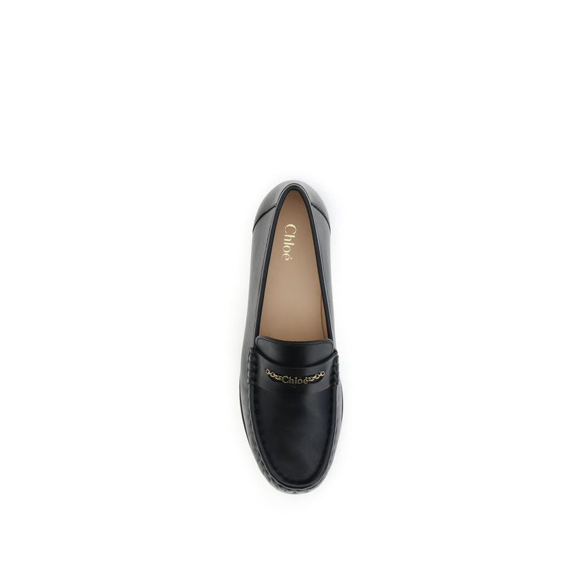 Black Calf Leather Bos Taurus Slip-On LoafersLeather Loafers by Chloé are crafted from fine polished calfskin and feature an elegant silhouette with refined pleated details. The upper is embellished with a subtle gold chain with the Chloé logo, lending a