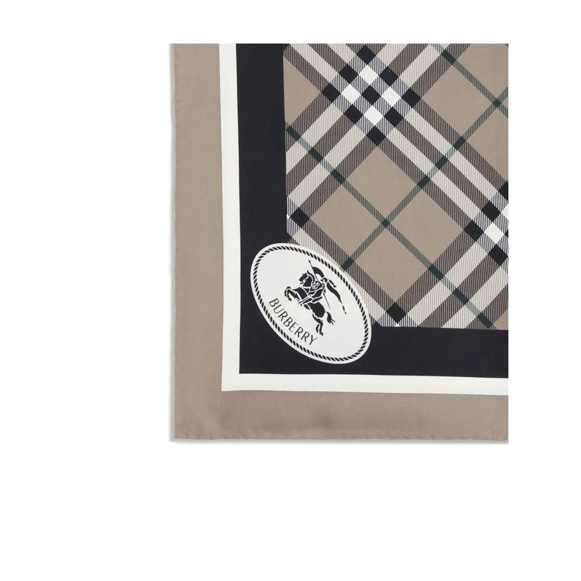 Beige Silk ScarfBurberry’s silk Scarf celebrates the house’s heritage with timeless elegance. Featuring the iconic all-over Archive Check pattern, it is embellished with the Equestrian Knight logo printed on one of the corners. Made of fine silk, it is th