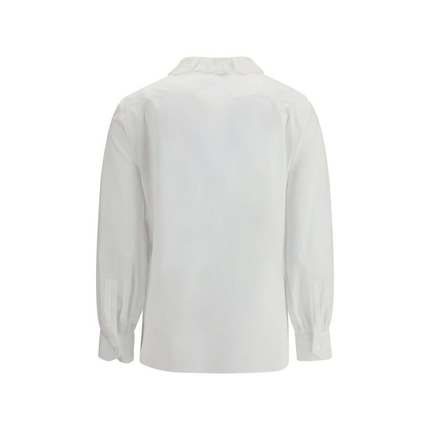 White Cotton Dress ShirtSaint Laurent’s cotton poplin Shirt combines sartorial rigor and romantic details in a sophisticated balance. Featuring a front button closure, it features a delicate Pierrot collar trimmed with lace that adds a feminine, retro tou