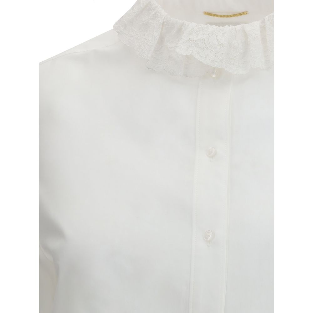 White Cotton Dress ShirtSaint Laurent’s cotton poplin Shirt combines sartorial rigor and romantic details in a sophisticated balance. Featuring a front button closure, it features a delicate Pierrot collar trimmed with lace that adds a feminine, retro tou