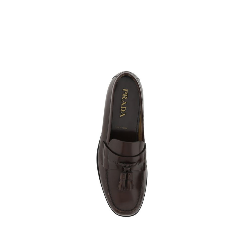 Brown Calf Leather Bos Taurus Slip-On LoafersCalfskin Loafers by Prada, slightly elongated round toe, leather block heel, front tray embellished with leather tassel, press-stamped logo insole, patent leather design. Season: AW25 Composition: 100% Calf Lea
