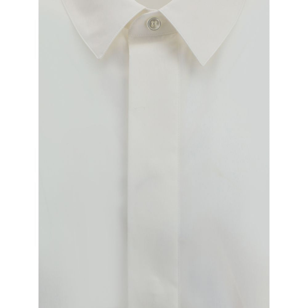 White Cotton Dress ShirtSaint Laurent’s cotton Shirt is a clean and elegant design. Made of cotton poplin, it features a classic collar, a front closure with concealed buttons for a minimal and neat effect, and a discreet but distinctive embroidered logo