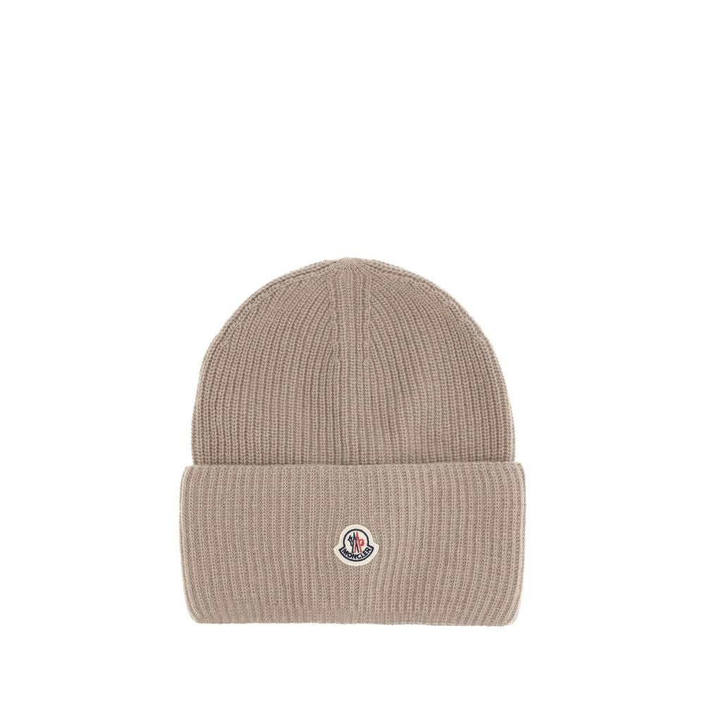 Beige Wool BeanieThe beanie hat by Moncler is a versatile wool accessory with a classic cut, perfect for both city days and outdoor adventures. Designed to provide warmth and comfort, this knitted hat is made from high-quality carded wool. The medium-weig