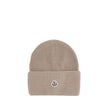 Beige Wool BeanieThe beanie hat by Moncler is a versatile wool accessory with a classic cut, perfect for both city days and outdoor adventures. Designed to provide warmth and comfort, this knitted hat is made from high-quality carded wool. The medium-weig
