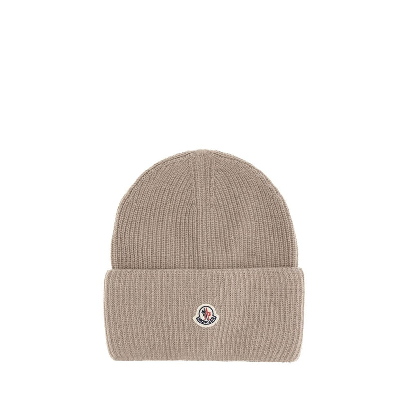 Beige Wool BeanieThe beanie hat by Moncler is a versatile wool accessory with a classic cut, perfect for both city days and outdoor adventures. Designed to provide warmth and comfort, this knitted hat is made from high-quality carded wool. The medium-weig