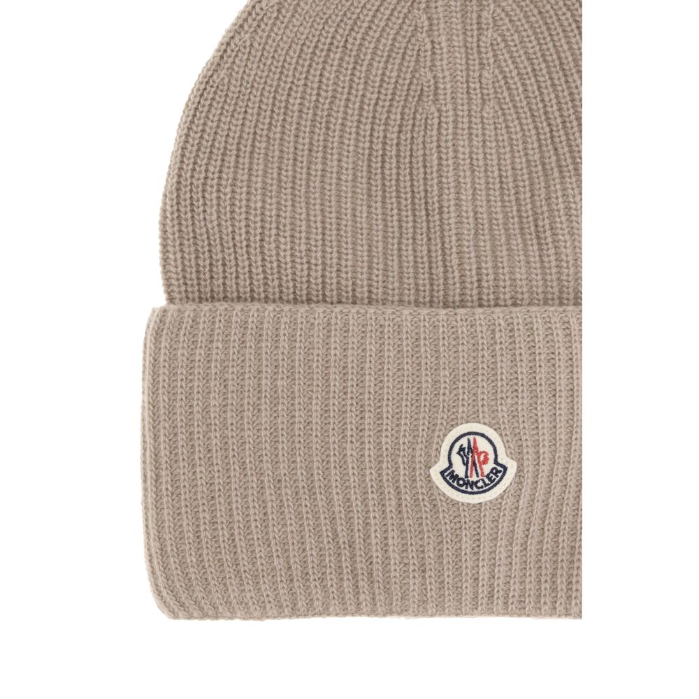 Beige Wool BeanieThe beanie hat by Moncler is a versatile wool accessory with a classic cut, perfect for both city days and outdoor adventures. Designed to provide warmth and comfort, this knitted hat is made from high-quality carded wool. The medium-weig